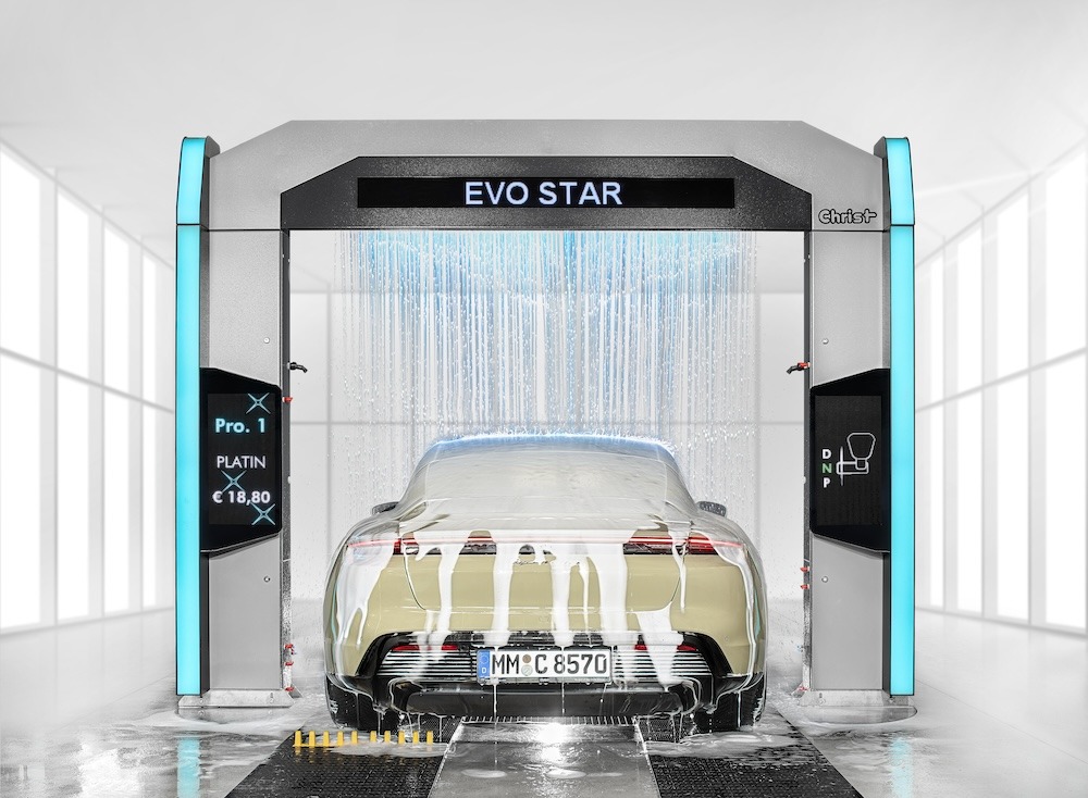 一个标有“EVO STAR”的现代洗车站，一辆车正在洗车，覆盖着泡沫，正被水流冲洗。
