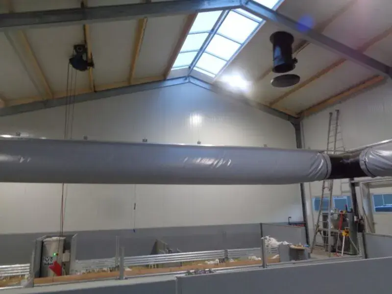 Interior view of a facility with overhead ventilation ducts and a skylight