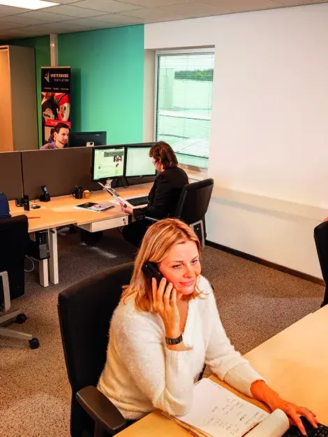 Vertriebsmitarbeiter telefoniert am Schreibtisch im Büro