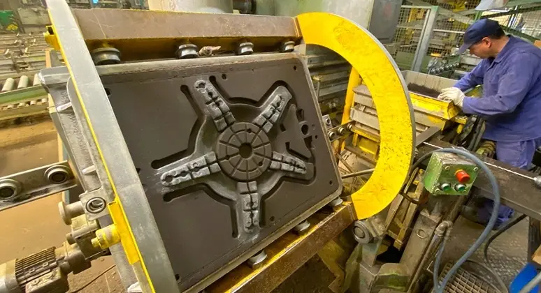 Worker operating a machine molding a part for industrial or medical use in a factory